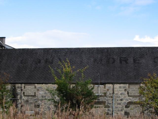 Historisches Steingebäude der ehemaligen Convalmore Distillery mit verblasstem Schriftzug