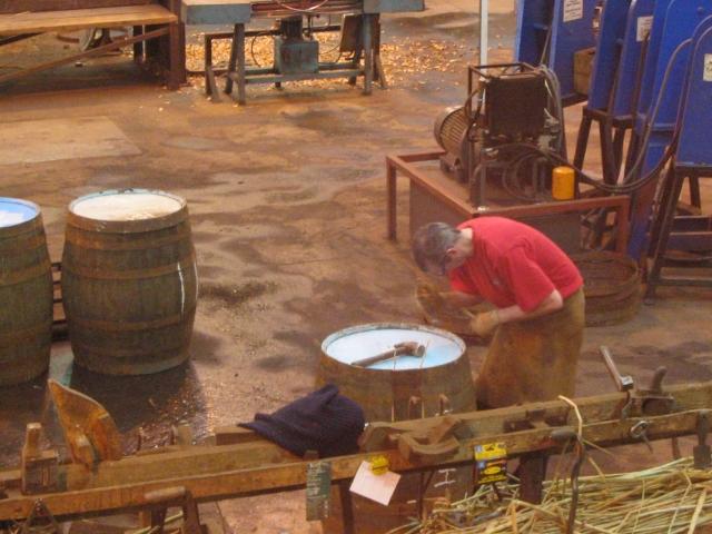 Küfer bei der handwerklichen Bearbeitung eines Fasses